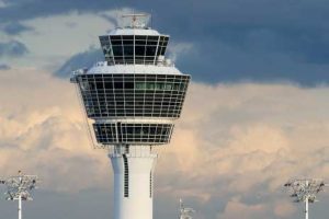 Flughafen-Tower vor einem leicht wolkigen blauen Himmel